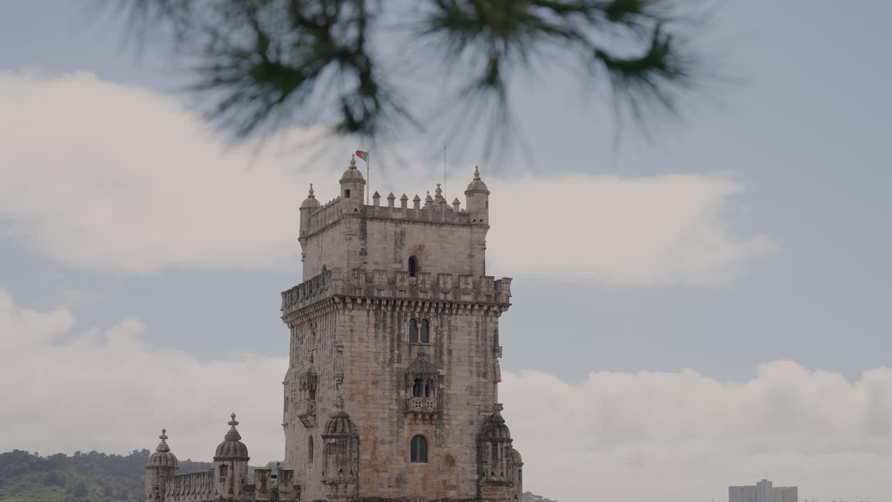 iconic torre de belem rises behind trees in lisbon portugal