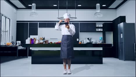 full body of asian woman chef looking at smartphone then screaming goal celebrating in home kitchen