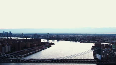 Aerial-view-in-front-of-he-Manhattan-bridge-and-the-East-river,-dawn-in-NYC,-USA