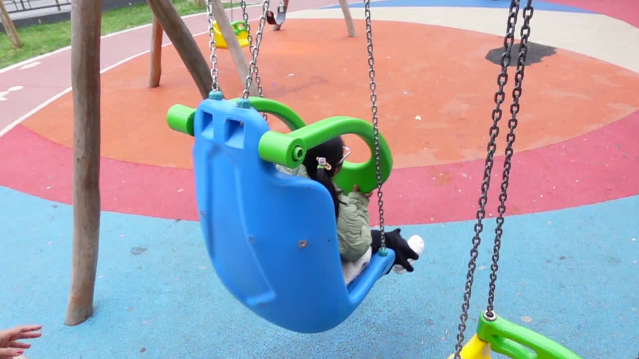 un niño en un columpio en un patio de recreo
