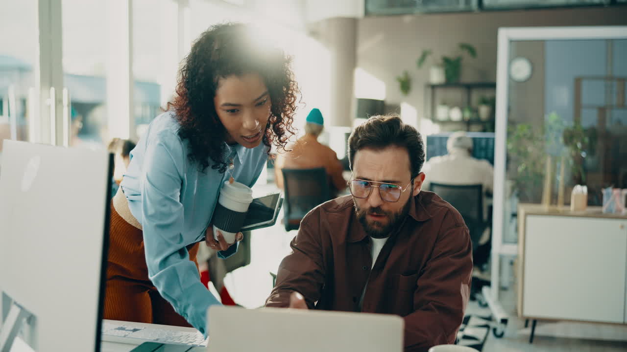 Two coworkers discussing a project in a modern office
