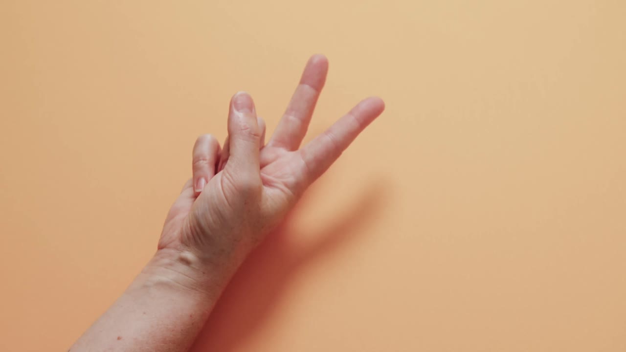 близкая рука какауской женщины, показывающая знак мира с копировальным пространством на желтом фоне