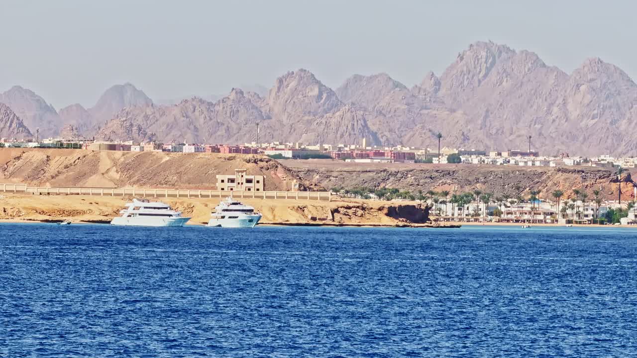Sunny Sharm El Sheikh coastline with blue sea and distant mountains