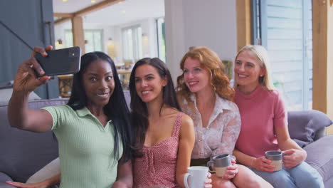 Grupo-Multicultural-De-Amigas-Sentadas-En-Un-Sofá-En-Casa-Posando-Juntas-Para-Selfie