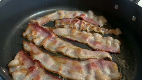 bacon cooking on stovetop in kitchen