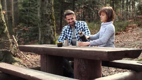 padre y su hijo bebiendo té caliente en el bosque/bielsko biala/polonia