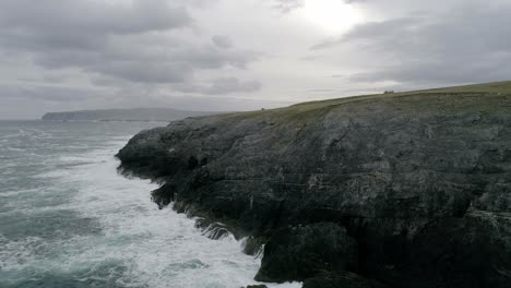 Epic-cliffside-aerial-with-rough-seas-thrashing-the-coastline