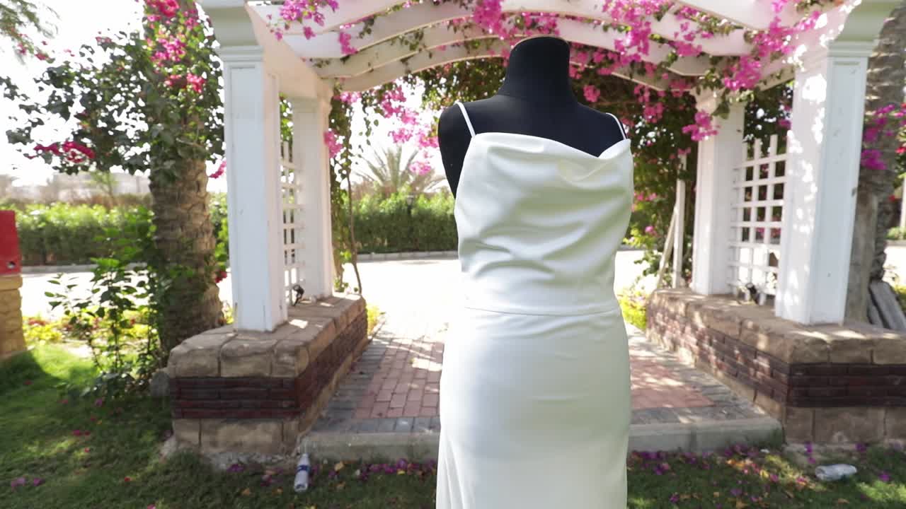 ⁇  드레스 인형은 꽃과 나무로 가득 찬 장식으로 둘러싸인 야외 결혼식에서