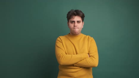 sad and angry man standing with arms crossed looking around