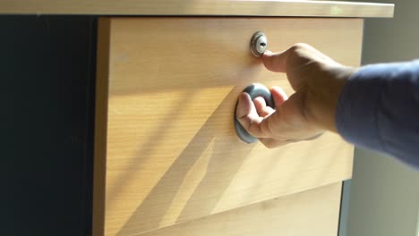 person opening a wooden drawer