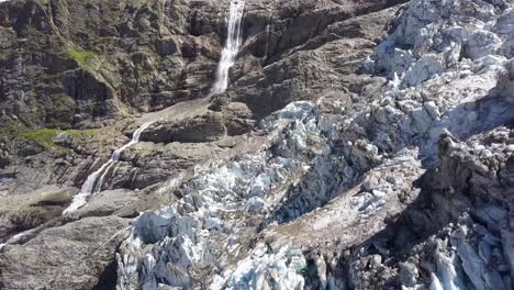 Vista-Aérea-Escénica-De-Un-Glaciar-Y-Una-Gran-Cascada-En-Los-Alpes-Suizos-En-Verano