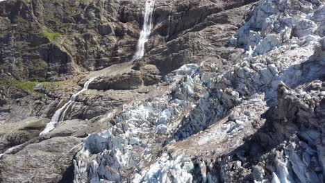 vista aérea escénica de un glaciar y una gran cascada en los alpes suizos en verano