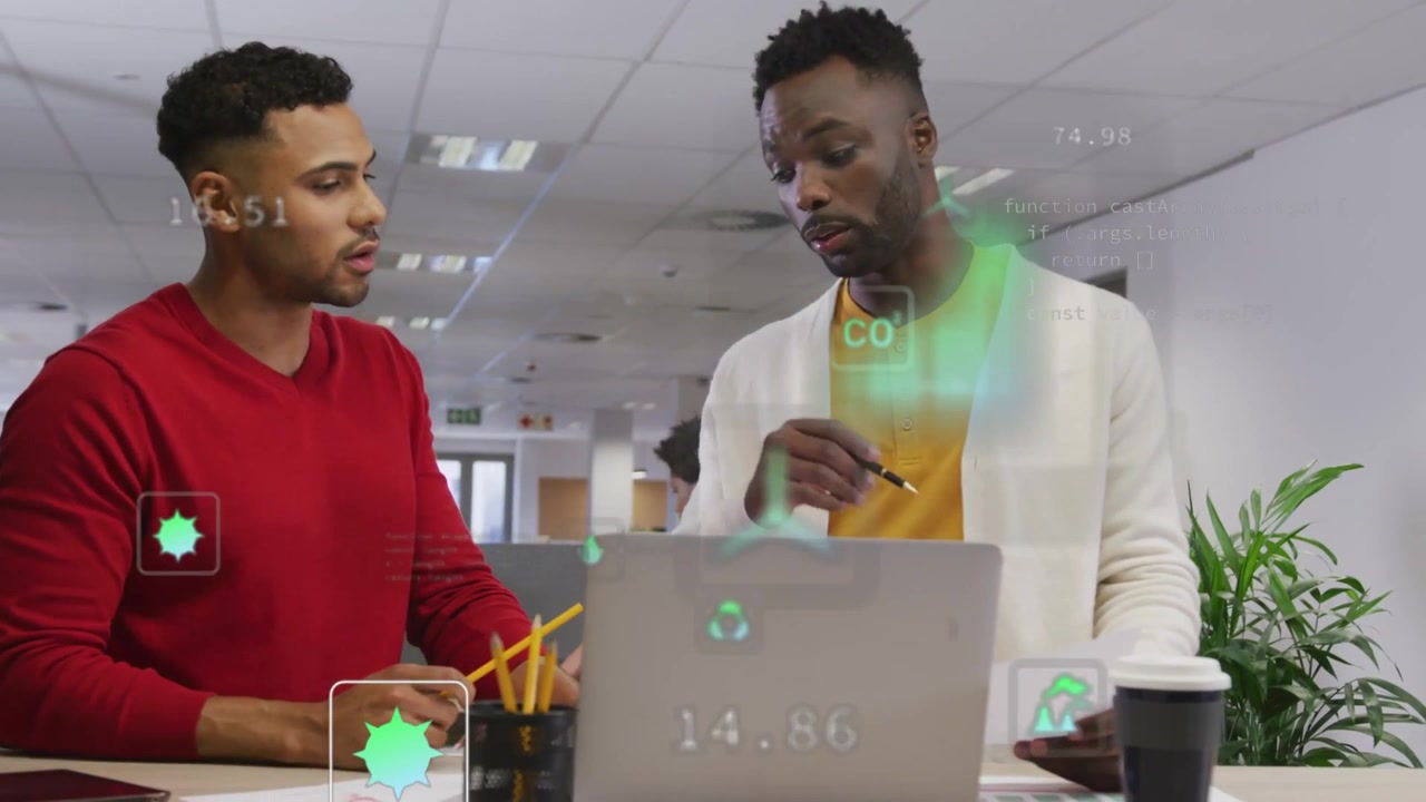 Left coworker pointing at laptop causing green AR graphs while right peer studying doc for business