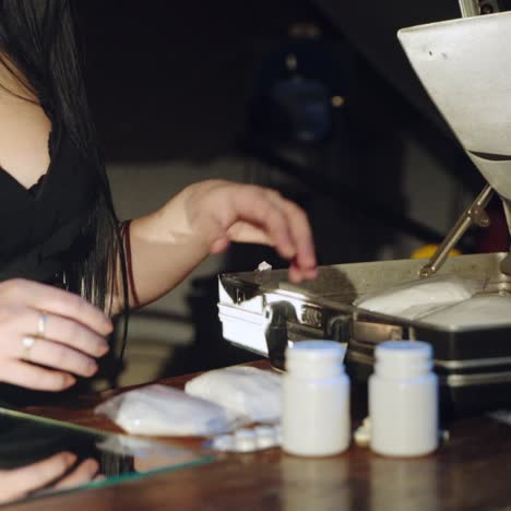 a man and a woman are packing drugs in a suitcase for sale. drug trade. illegal business