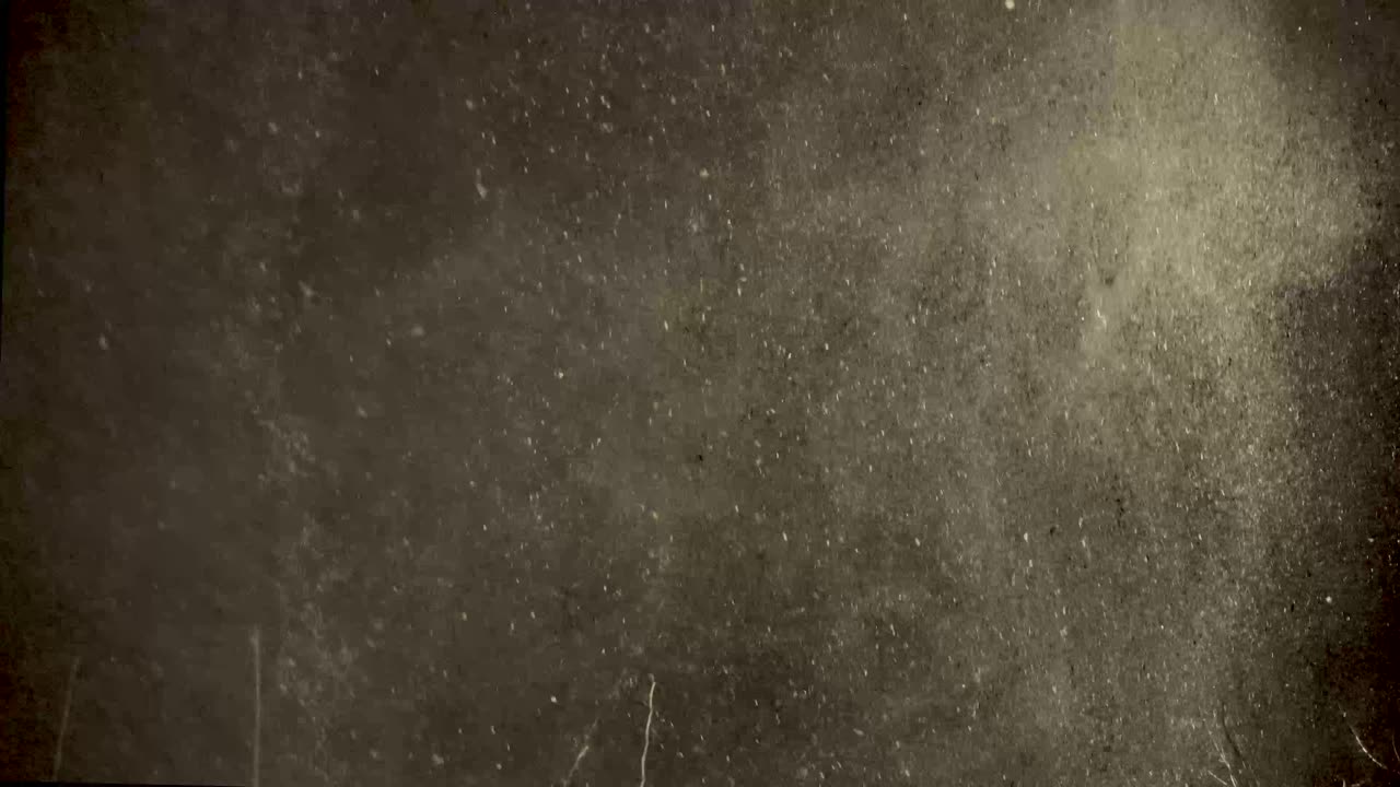 Swirls of snow drift in and out of view of the house light during this heavy winter storm late at night in this steady clip