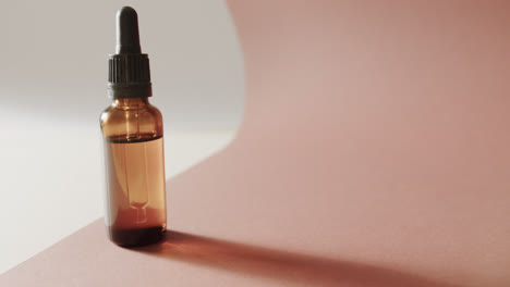 Close-up-of-glass-bottle-with-pump-and-copy-space-on-pink-background