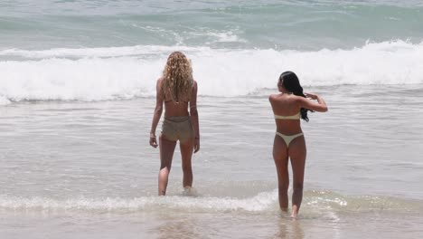 two women playing and splashing in ocean waves