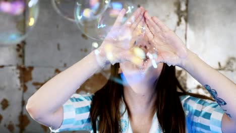 woman blowing through her hands soap bubbles