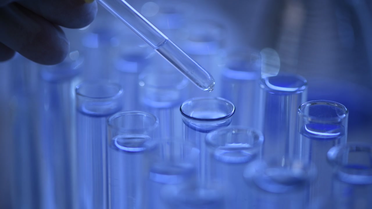 Esperimento scientifico: pipetta che rilascia liquido in provette