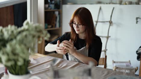 a girl with glasses a potter forms her product