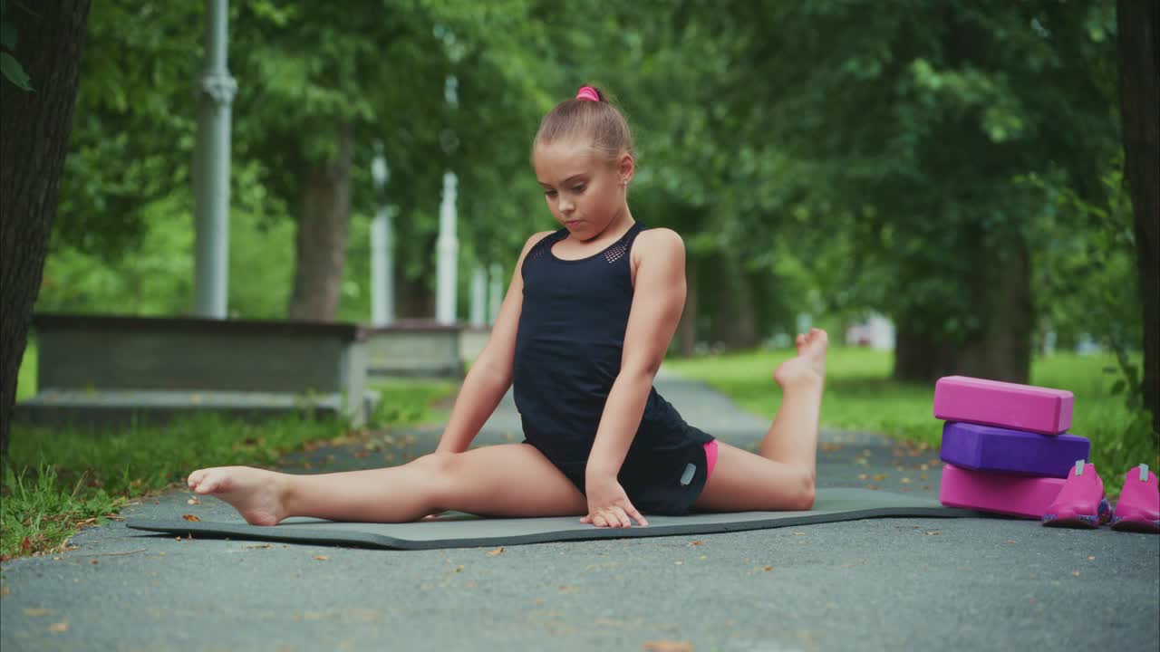 A Young Girl Demonstrates Incredible Flexibility and Strength in a Beautiful Outdoor Yoga Practice, Showcasing Skillful Poses and Calm Concentration