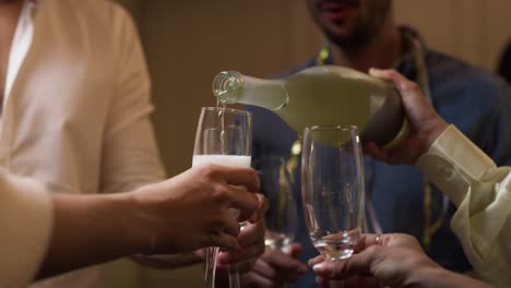 friends pouring champagne on the party