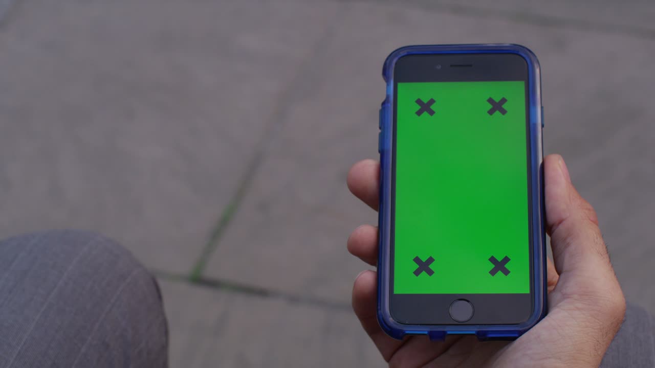 pantalla verde de la llave de croma del teléfono celular con la mano