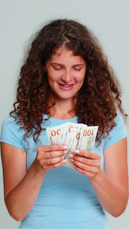 woman counting cash dollars money happily satisfied celebrating salary savings financial earnings
