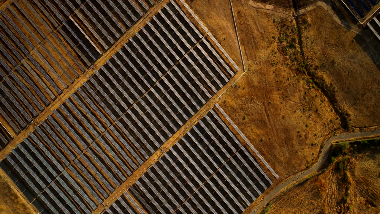 Solcellepark i Romeral, geometrisk mønster i tørt landskab, vedvarende energi eller abstrakte teknologibaggrunde, Chile. Luftfoto, top-down fremad.