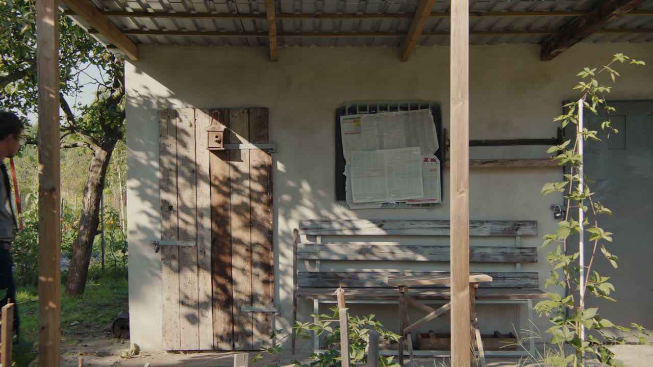 Man near a rustic shed in a garden