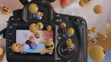 animación de emojis sobre el visor de la cámara con vlogger de fitness femenino haciendo ejercicio en casa