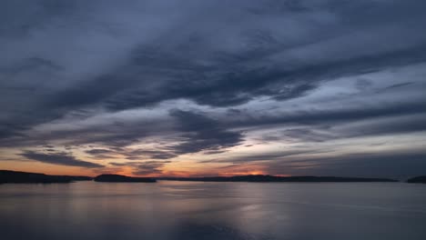 Cielos-Oscuros-Y-Malhumorados-Se-Reflejan-En-Las-Aguas-Negras-Y-Moradas,-Hiperlapso-Aéreo