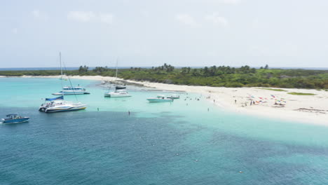 AERIAL---People-on-boats-on-clear-waters,-Cayo-Icacos,-Puerto-Rico,-spinning-shot