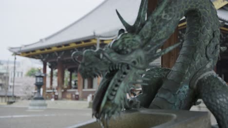 dragon hand washing station chozuya, focus pull reveals higashi honganji temple