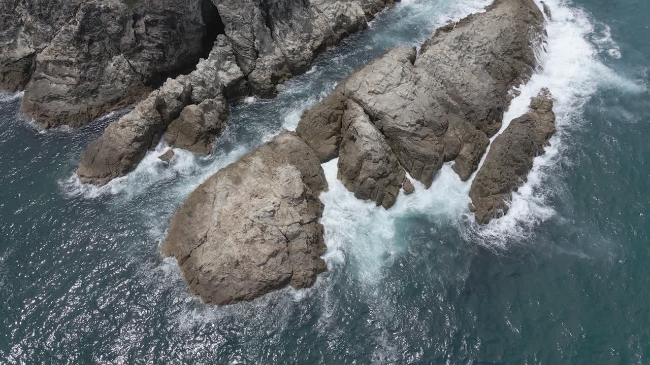 Onde dell'oceano che si infrangono contro la costa rocciosa di Headland Park vicino a South Gorge Beach - Point Lookout, North Stradbroke Island, Australia