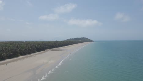 people walking along four mile beach in port douglas, queensland, australia - aerial drone shot