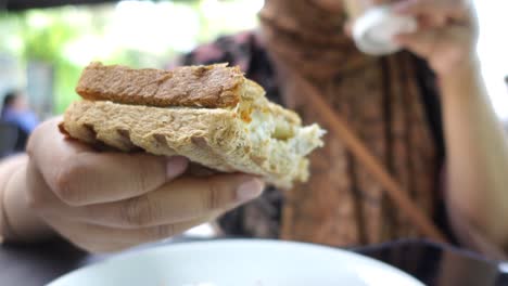 woman eating a grilled cheese sandwich