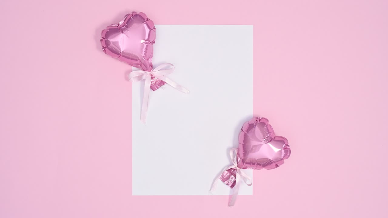 두 개의 분홍색 심장 풍선은 발렌타인 데이를 위해  종이 카드 메모에 이동합니다.