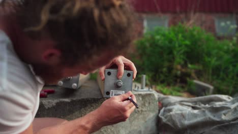 A-Man-Screwing-Galvanized-Base-On-The-Wooden-Block