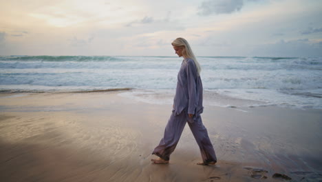 carefree woman walking sunset shore. relaxed girl admiring beautiful sea waves