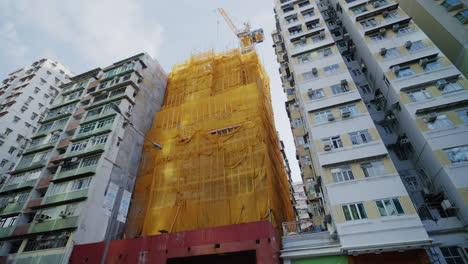 edificio de cubierta de red de escombros naranja en construcción entre rascacielos
