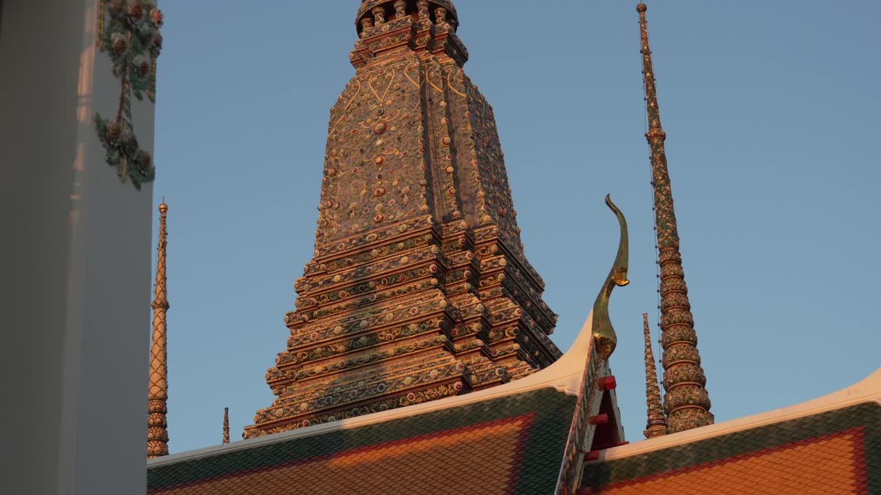 Wat Pho, un templo budista sagrado, que exhibe una intrincada arquitectura chedi y tejados de tejas tradicionales bajo un cielo despejado, representando la devoción espiritual y la cultura tailandesa en Bangkok, Tailandia