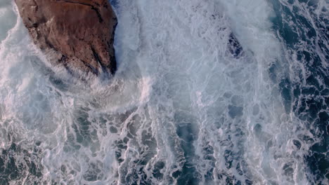 Vista-Aérea-De-Las-Olas-Del-Océano-Se-Rompe-En-Las-Rocas