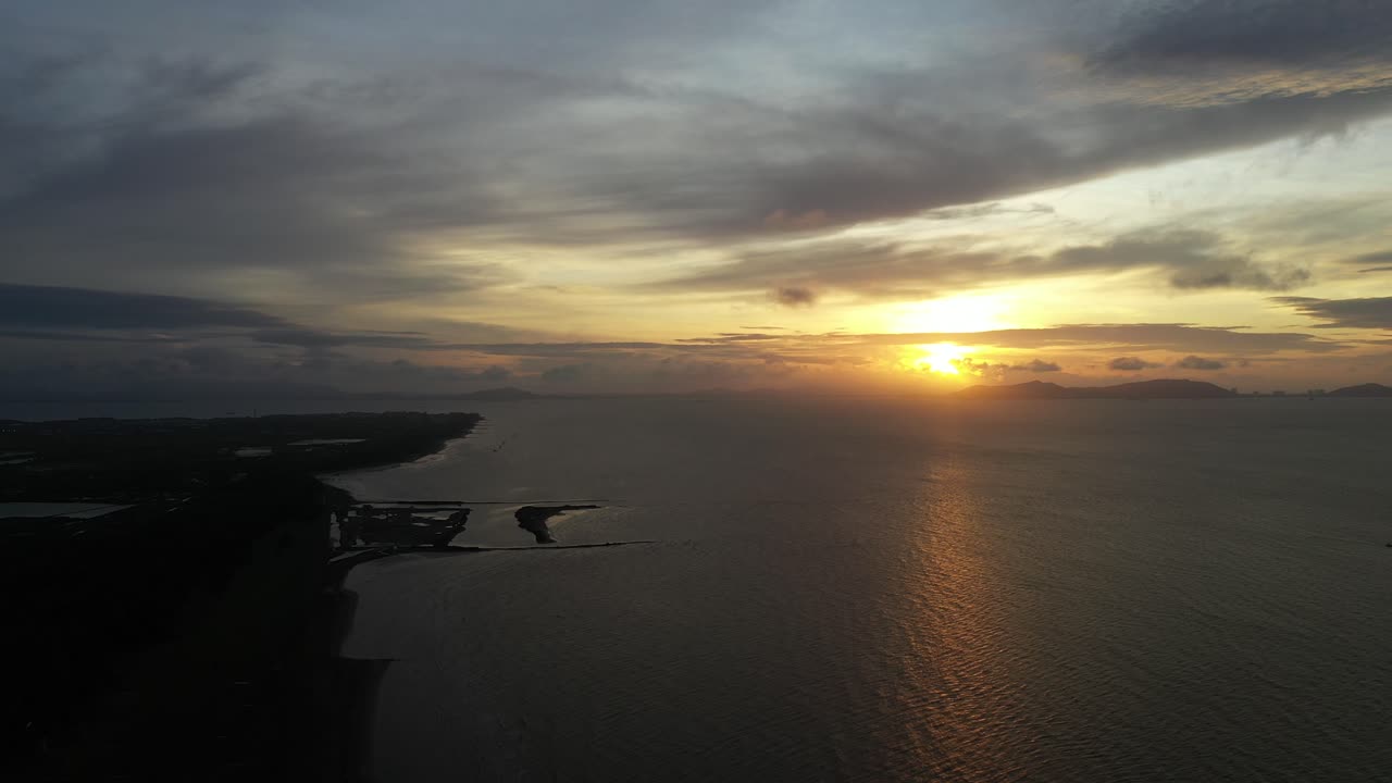 베트남 칸 지오에서 다채로운 움직이는 구름과 함께 해안과 물 위의 일출의 공중 패닝 전망