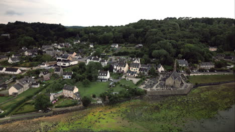 Backward-Dolly-Aerial-Reveals-French-Village-of-Landévennec-With-River,-Church-and-Cemetery