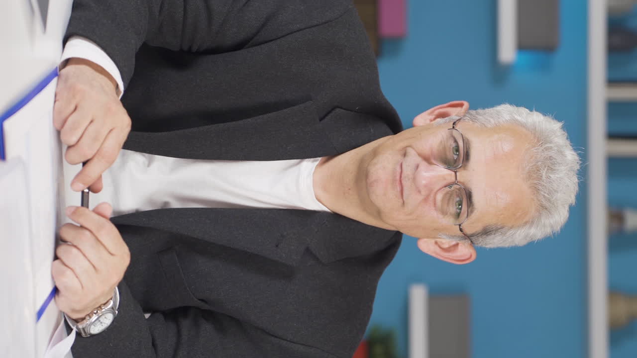 vídeo vertical de un trabajador de oficina en casa asintiendo a la cámara.