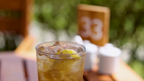 un vaso de refresco con lima se sienta en una mesa iluminada por el sol, mostrando condensación y burbujas, creando una vibración refrescante de verano