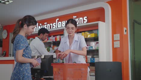 asian female pharmacist selling drugs to customers.