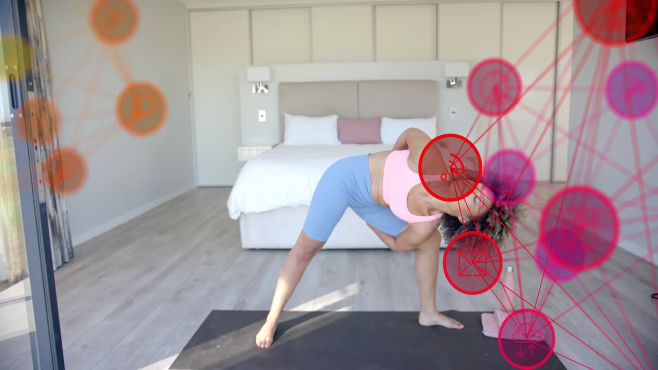 Woman following guided yoga cue, doing twist on black mat with sun patch and moving circles