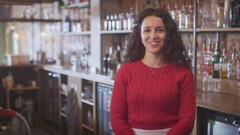 retrato de una trabajadora de bar sonriente de pie detrás del mostrador